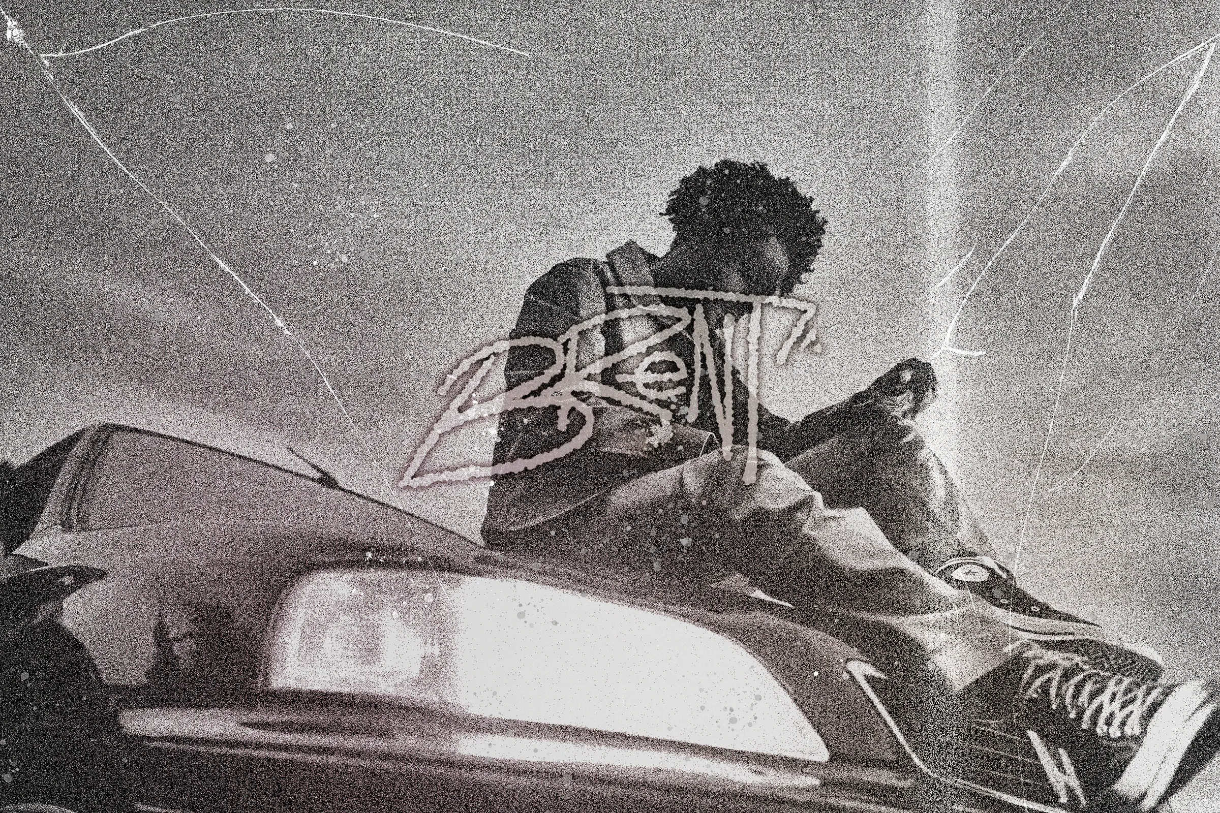 Grainy black-and-white image of a man sitting on the bonnet of a car with headlights glowing, with a chrome scrawled signature over him.