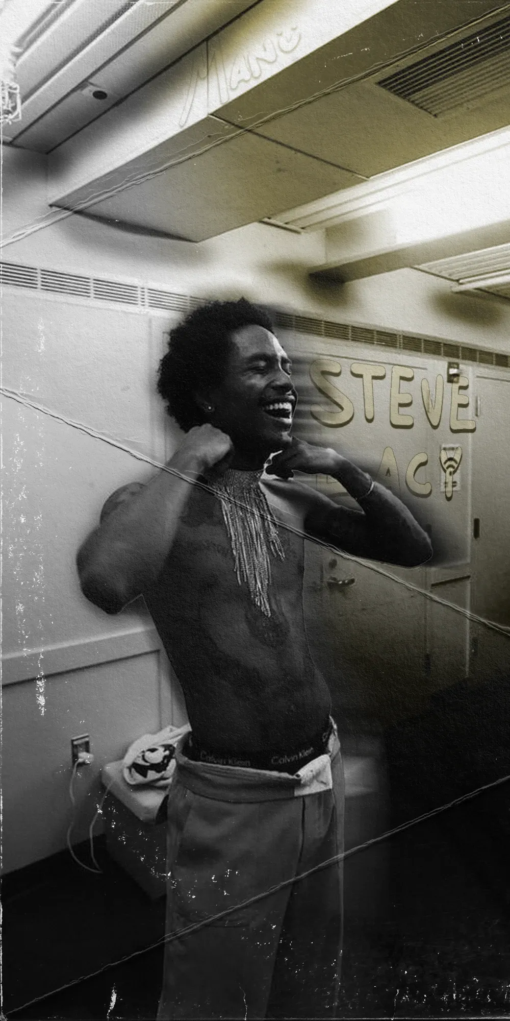 Tall black-and-white photo of a shirtless smiling musician backstage with his hands behind his head, with Steve lettered on the wall behind him.